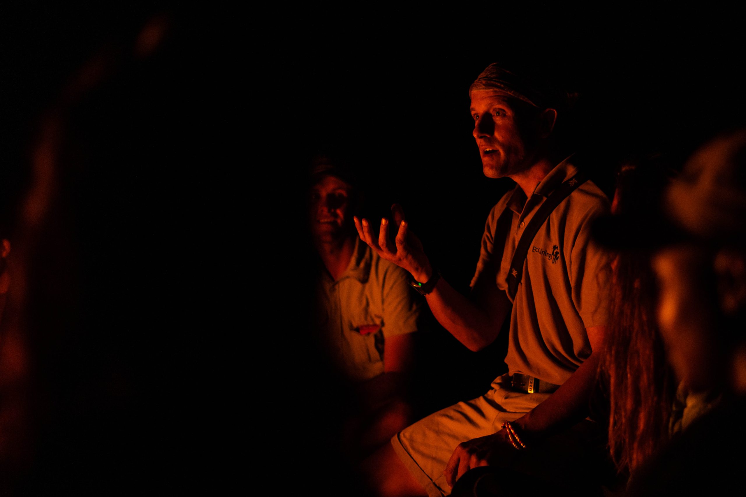 Wildlife lecturer at campfire at night